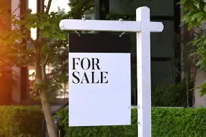 A white and black "for sale" sign